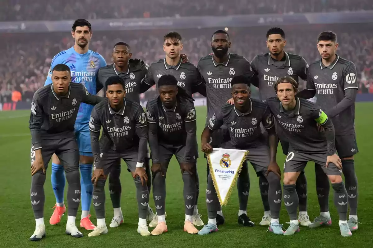 A soccer team posing for a group photo on the field before a match. A soccer team posing for a group photo on the field before a match.