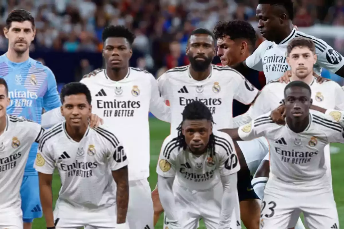 Real Madrid soccer players posing on the field in their white uniforms.