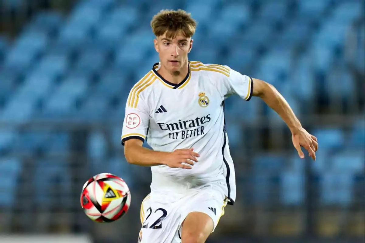 Real Madrid player in action during a match with the ball in the foreground and blurred stands in the background Real Madrid player in action during a match with the ball in the foreground and blurred stands in the background