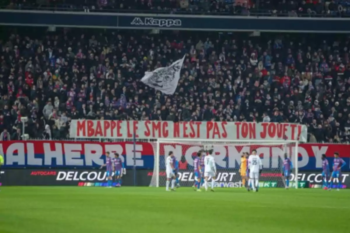 A football stadium filled with fans with a banner reading 