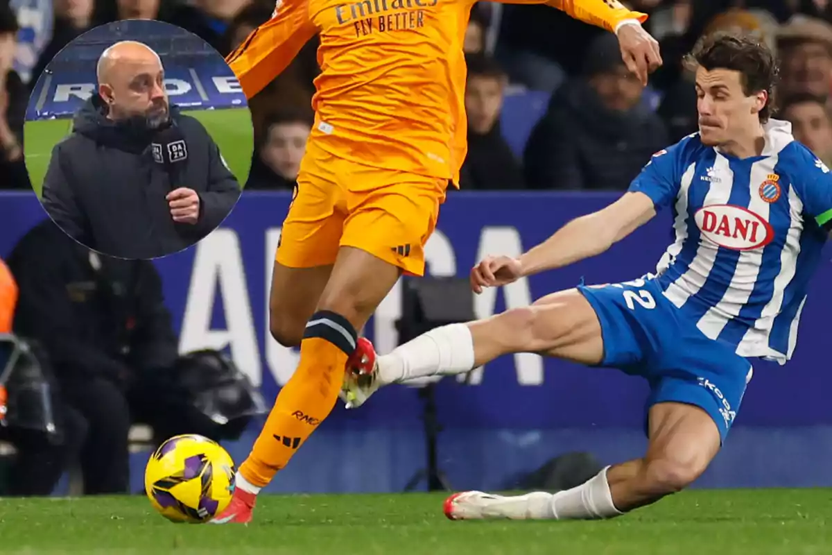 A soccer player in an orange uniform is challenged by a player in a blue and white uniform during a match, while a commentator watches in a small frame.