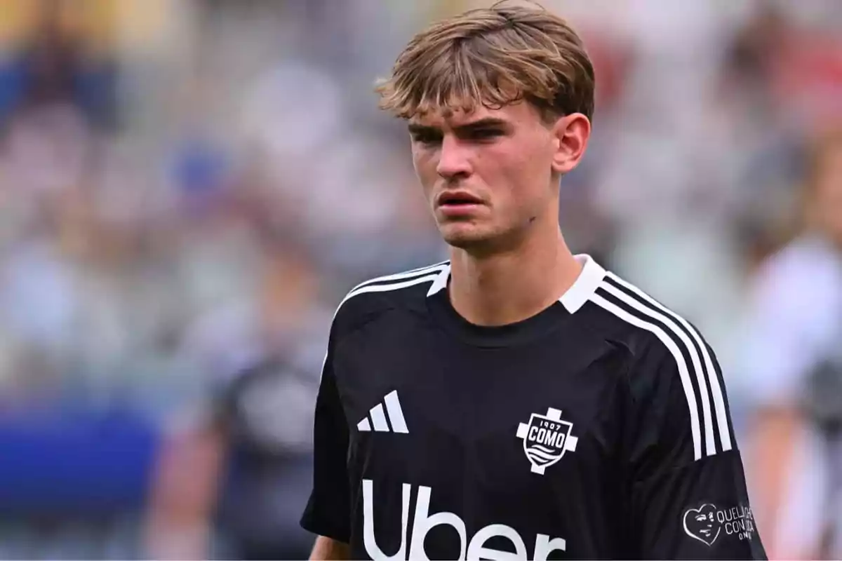 Young footballer wearing a black Como 1907 club jersey during a match Young footballer wearing a black Como 1907 club jersey during a match