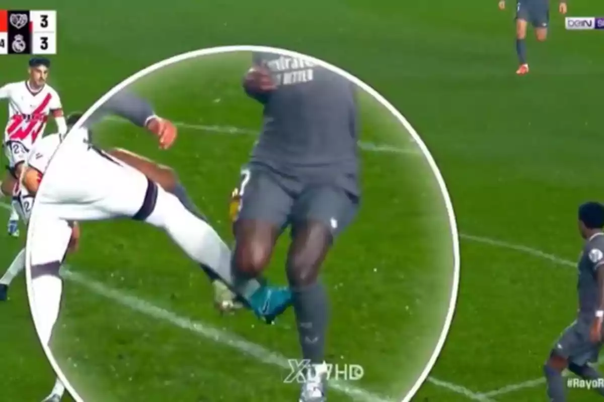 A soccer player in a white uniform makes a tackle on another player in a gray uniform during a match. A soccer player in a white uniform makes a tackle on another player in a gray uniform during a match.