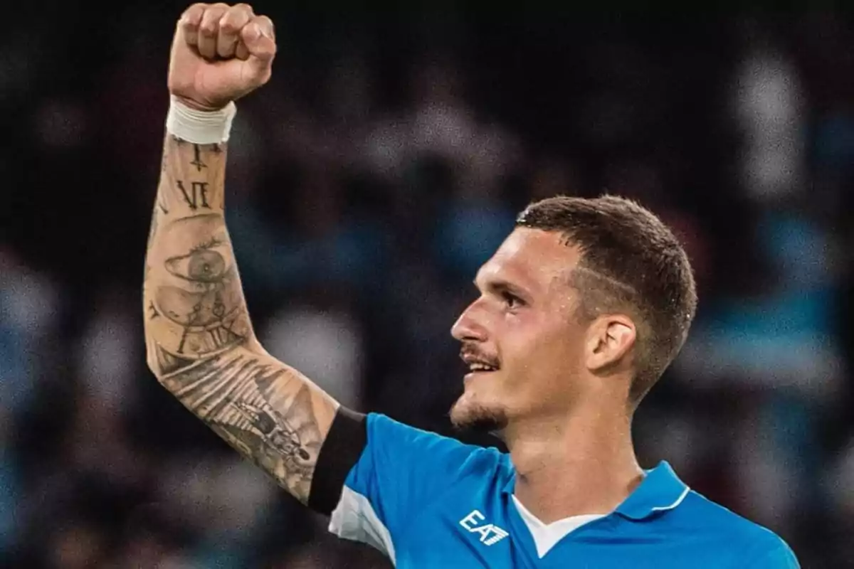 A player in a blue uniform raises his fist in celebration, showing a tattoo on his arm. A player in a blue uniform raises his fist in celebration, showing a tattoo on his arm.