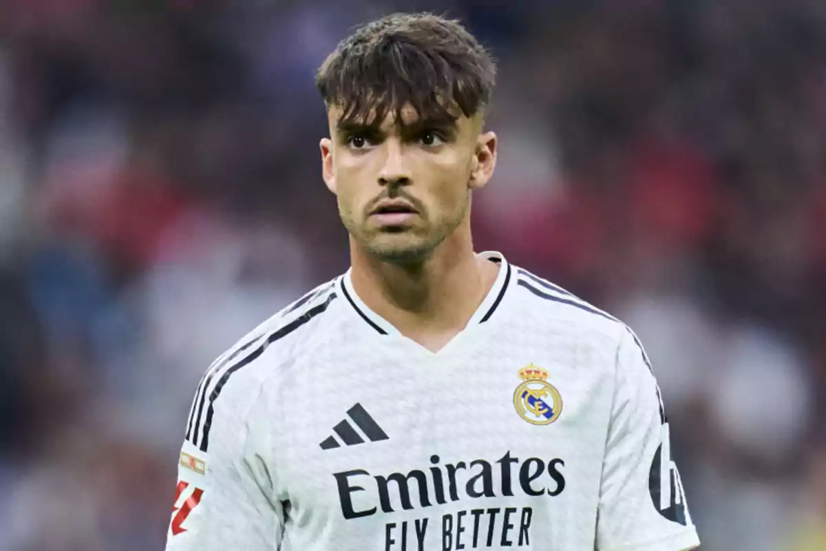 Soccer player in a white Real Madrid jersey on the field.