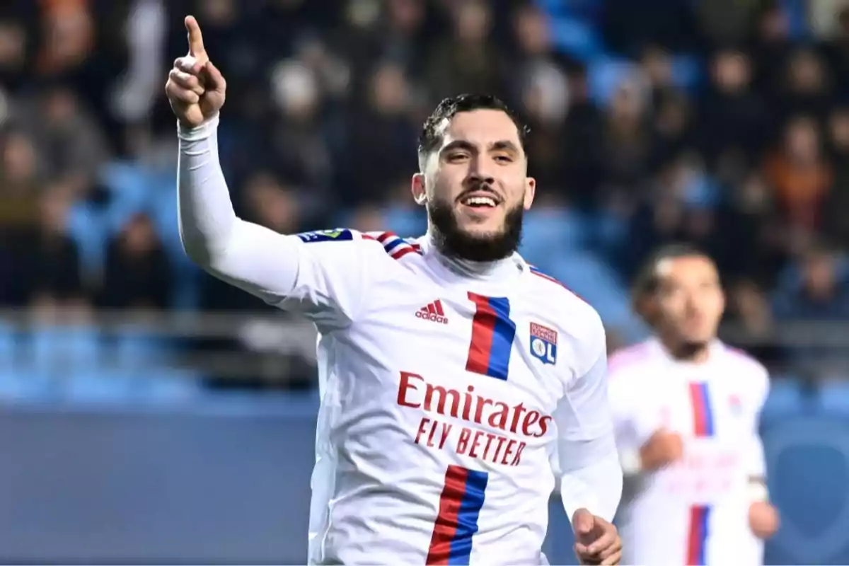 Olympique Lyon footballer celebrating a goal with his right arm raised and pointing upwards during a match Olympique Lyon footballer celebrating a goal with his right arm raised and pointing upwards during a match