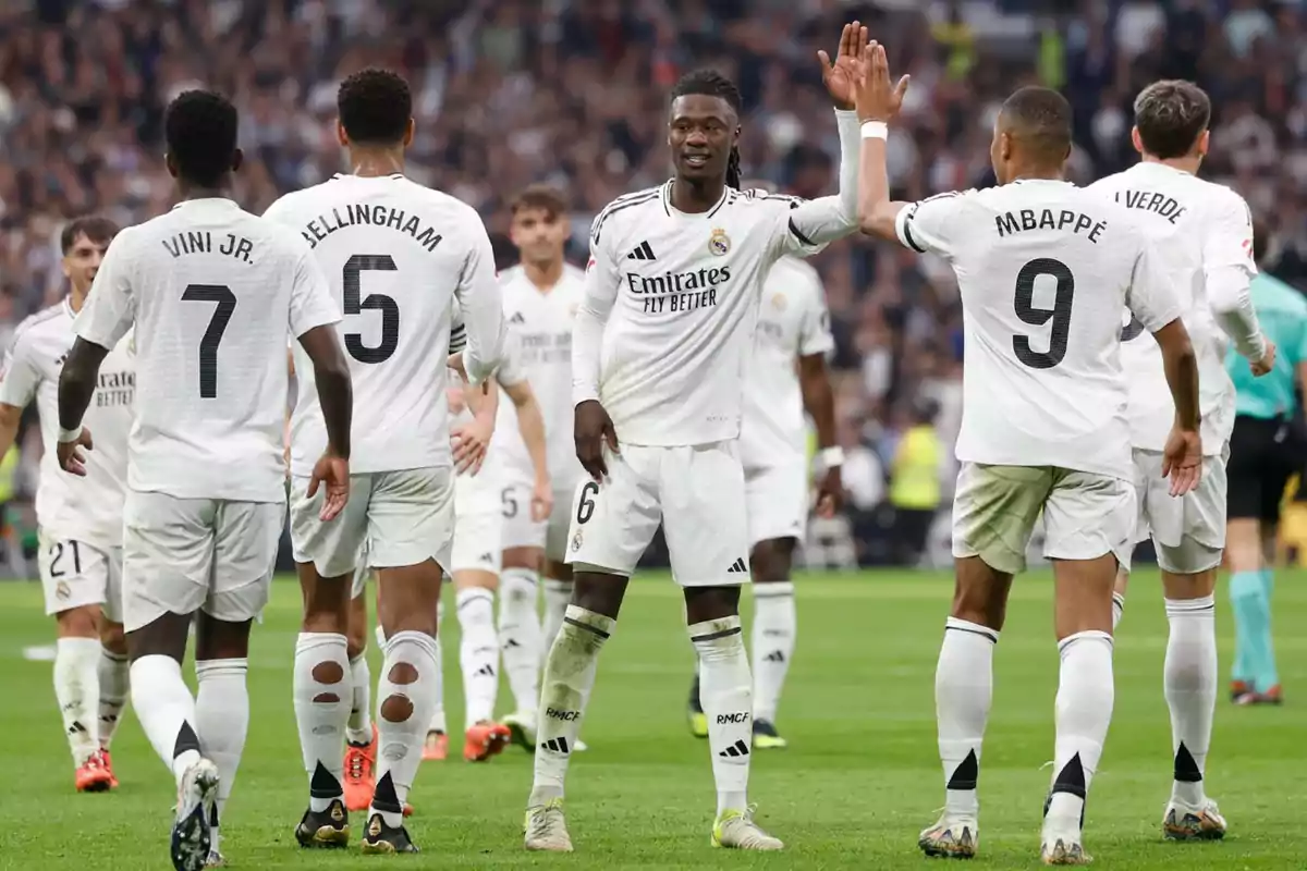 Jugadores de fútbol del Real Madrid celebrando en el campo durante un partido.