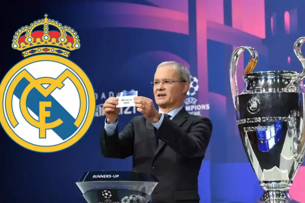 Un hombre en un sorteo de la UEFA Champions League sostiene un papel con el nombre de un equipo mientras el trofeo está a su lado y el logo del Real Madrid se muestra en la imagen.