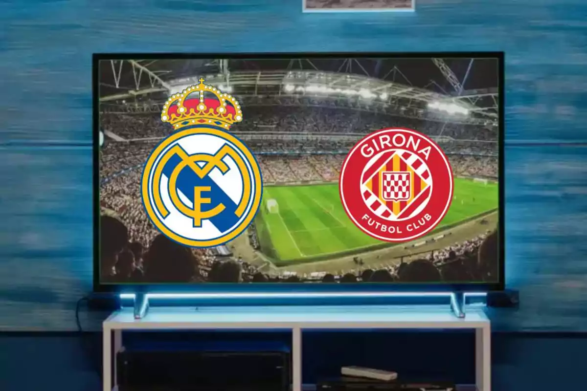 Logos de dos equipos de fútbol, Real Madrid y Girona, en la pantalla de un televisor mostrando un estadio lleno de espectadores.