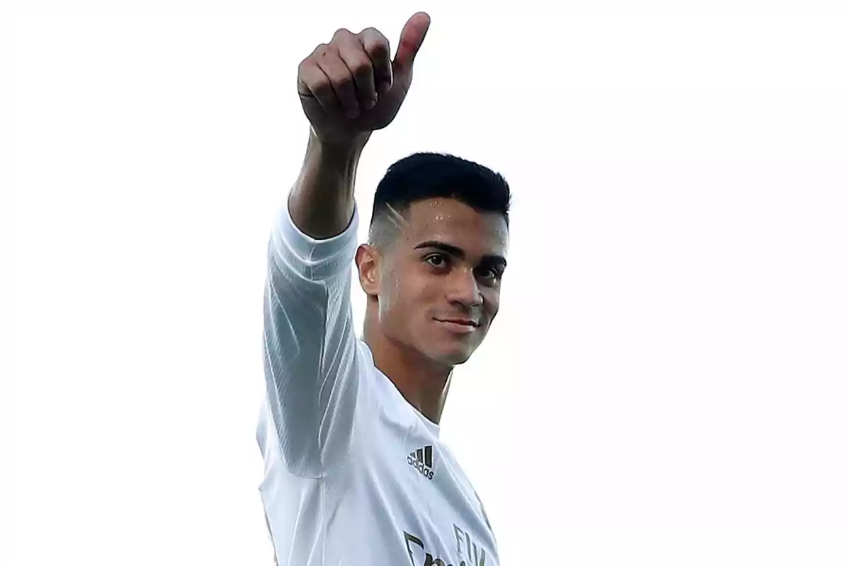 Joven con camiseta blanca levantando el pulgar en señal de aprobación Joven con camiseta blanca levantando el pulgar en señal de aprobación