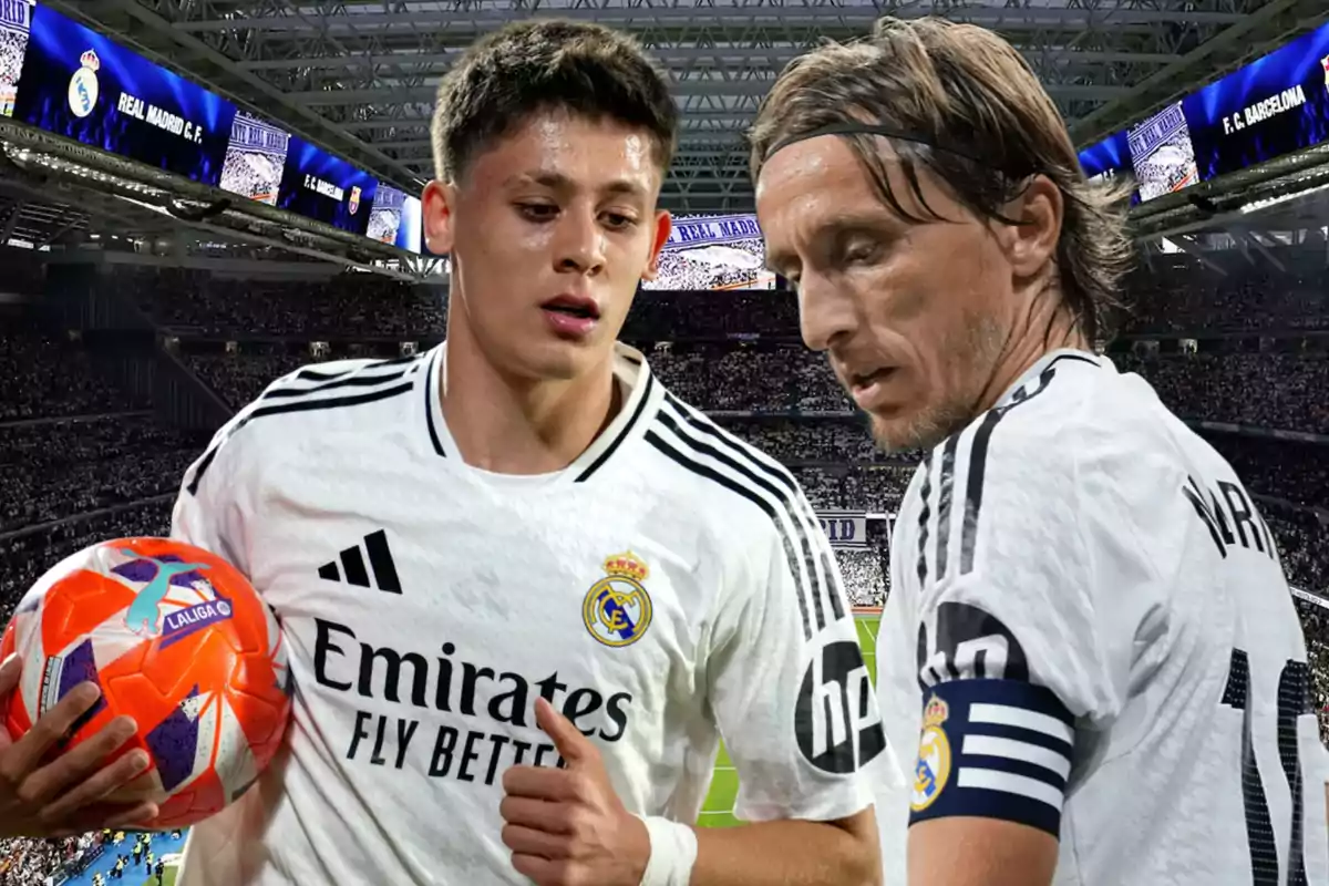 Dos futbolistas del Real Madrid con uniforme blanco en un estadio lleno, uno sostiene un balón naranja y el otro lleva un brazalete de capitán