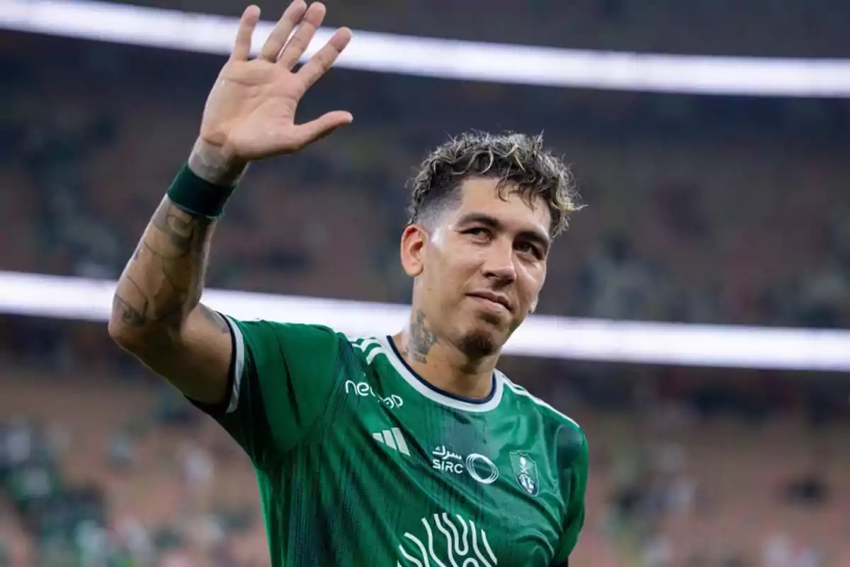 Soccer player in a green uniform waving in a stadium Soccer player in a green uniform waving in a stadium