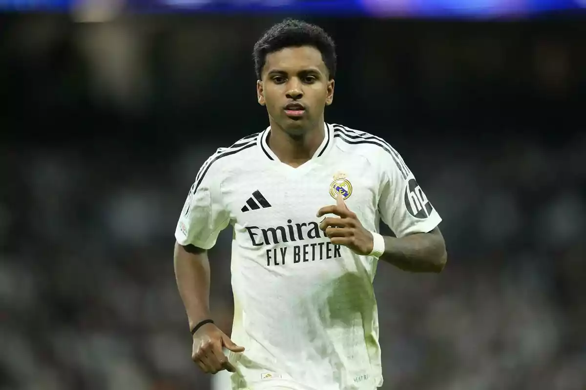 Un jugador de fútbol con el uniforme blanco del Real Madrid corriendo en el campo durante un partido. Un jugador de fútbol con el uniforme blanco del Real Madrid corriendo en el campo durante un partido.