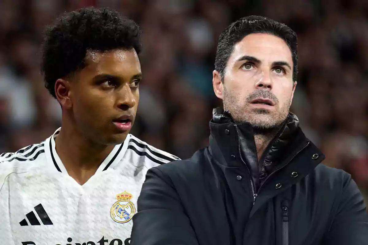 Dos hombres en un campo de fútbol, uno con uniforme del Real Madrid y el otro con chaqueta negra, mirando en direcciones opuestas.