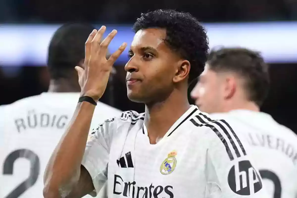 A player from Real Madrid on the field raising his hand. A player from Real Madrid on the field raising his hand.
