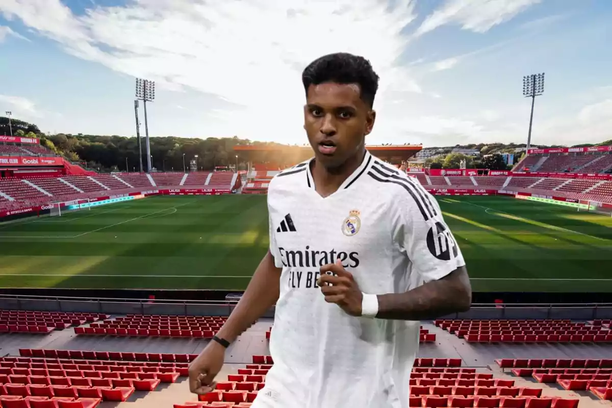 Un jugador de fútbol con uniforme blanco corre en un estadio vacío al atardecer.