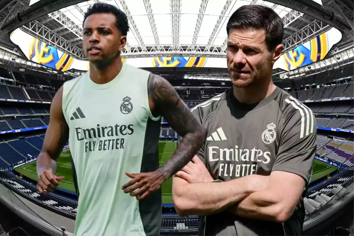 Dos personas con ropa de entrenamiento del Real Madrid están en el interior de un estadio de fútbol moderno