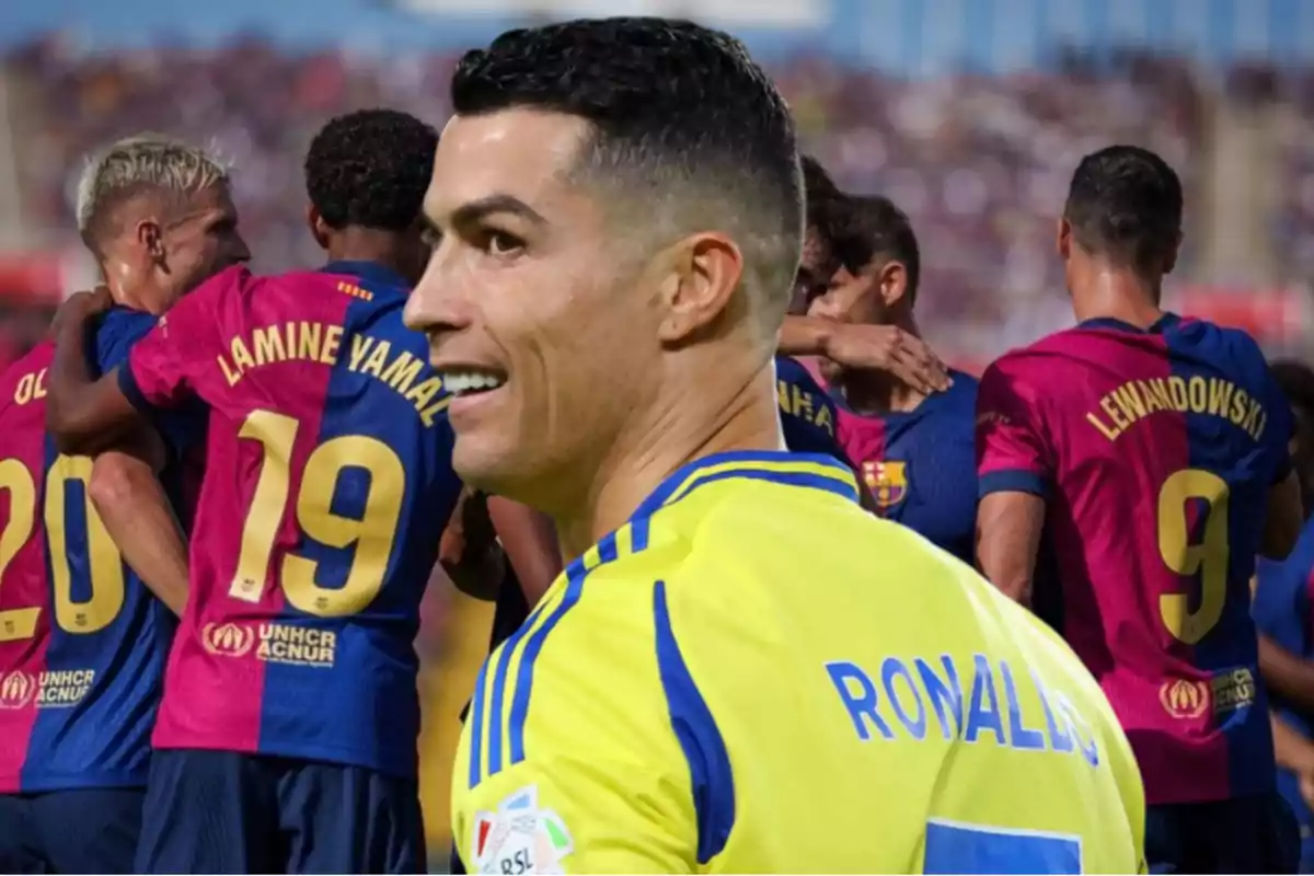 A player in a yellow and blue jersey smiles while in the background a group of FC Barcelona players is celebrating.