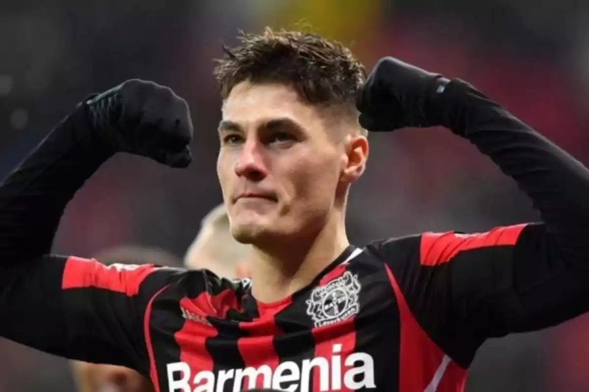 Soccer player in a Bayer Leverkusen uniform celebrating with flexed arms showing strength Soccer player in a Bayer Leverkusen uniform celebrating with flexed arms showing strength