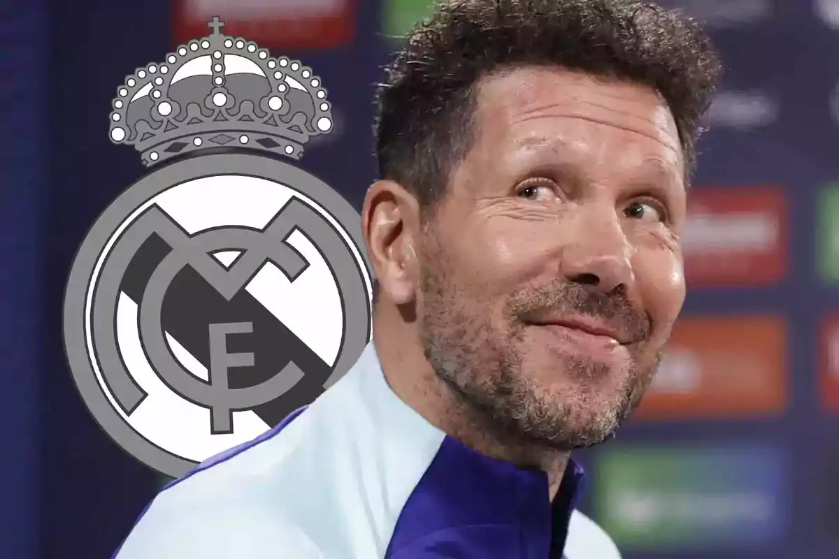 A smiling man with the Real Madrid logo in the background.
