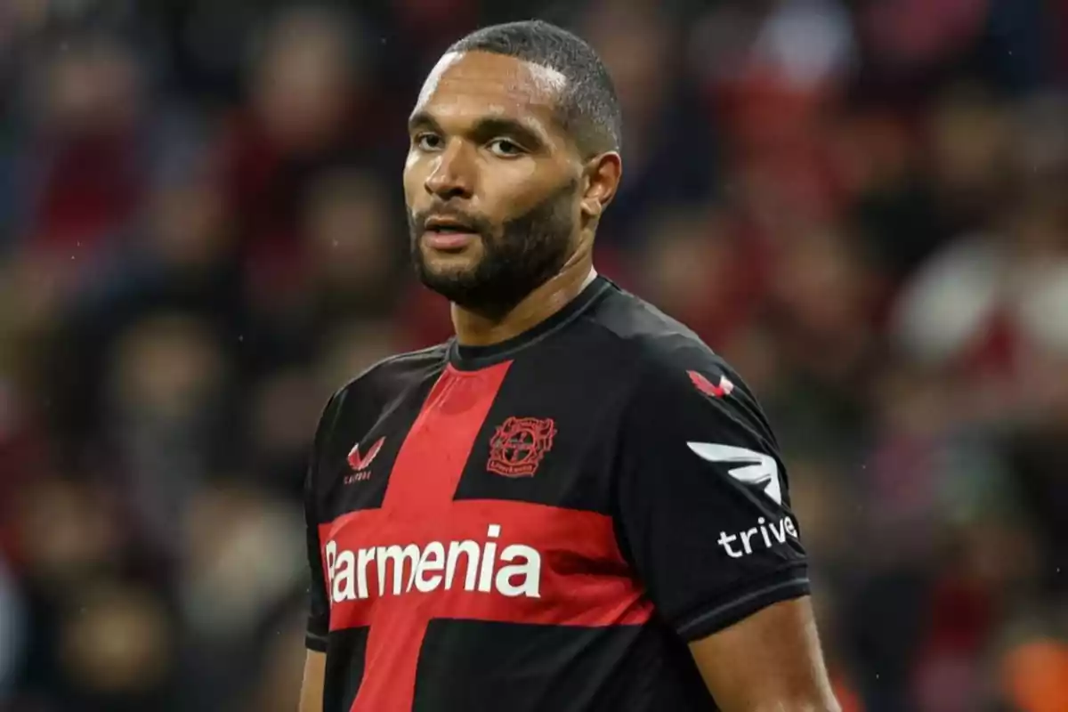 A soccer player in a black and red uniform on the field. A soccer player in a black and red uniform on the field.