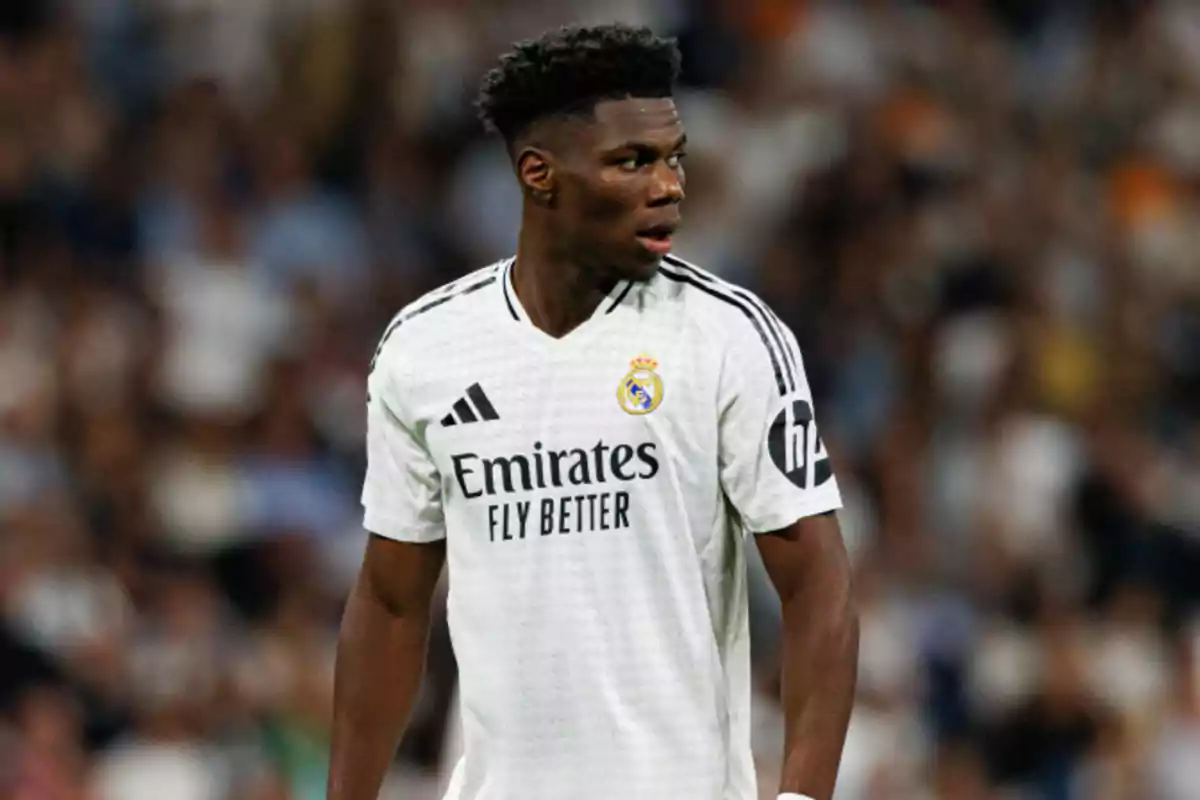 A player in the white Real Madrid uniform on the playing field.