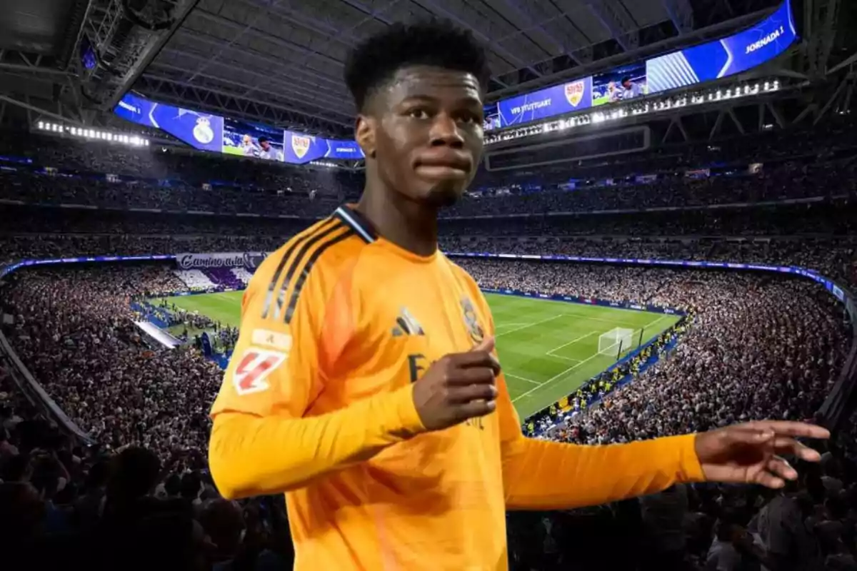 A soccer player in an orange uniform in a stadium full of spectators.