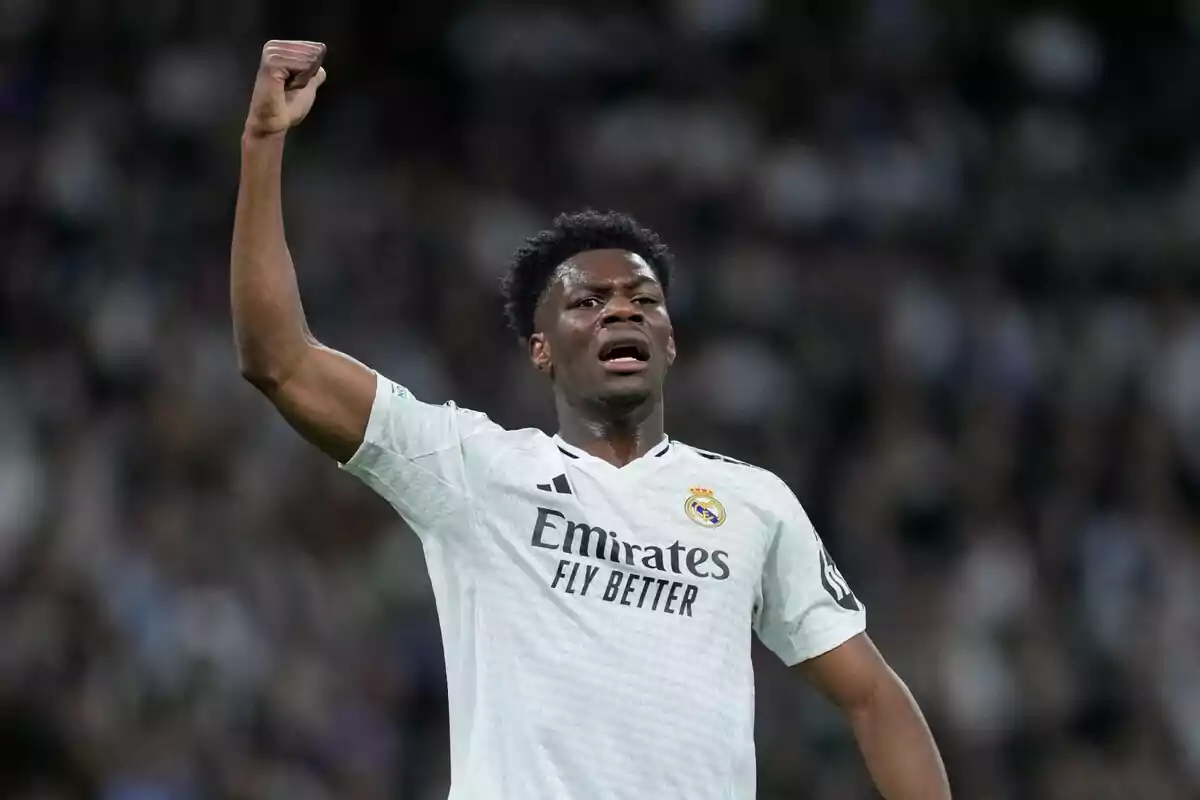 Un jugador de fútbol del Real Madrid levanta el brazo en señal de celebración durante un partido. Un jugador de fútbol del Real Madrid levanta el brazo en señal de celebración durante un partido.