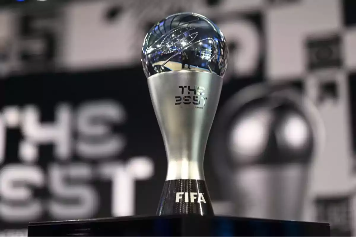 Trofeo plateado y negro de los premios FIFA The Best con fondo desenfocado.