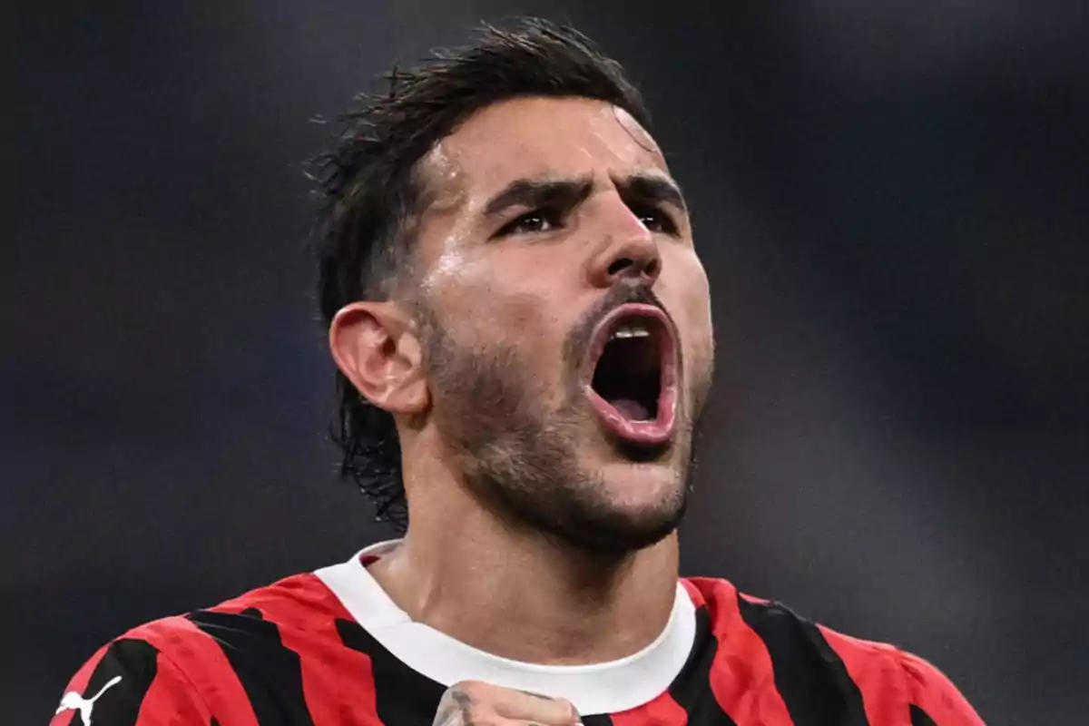 Un jugador de fútbol con uniforme rojo y negro celebra con expresión de emoción.