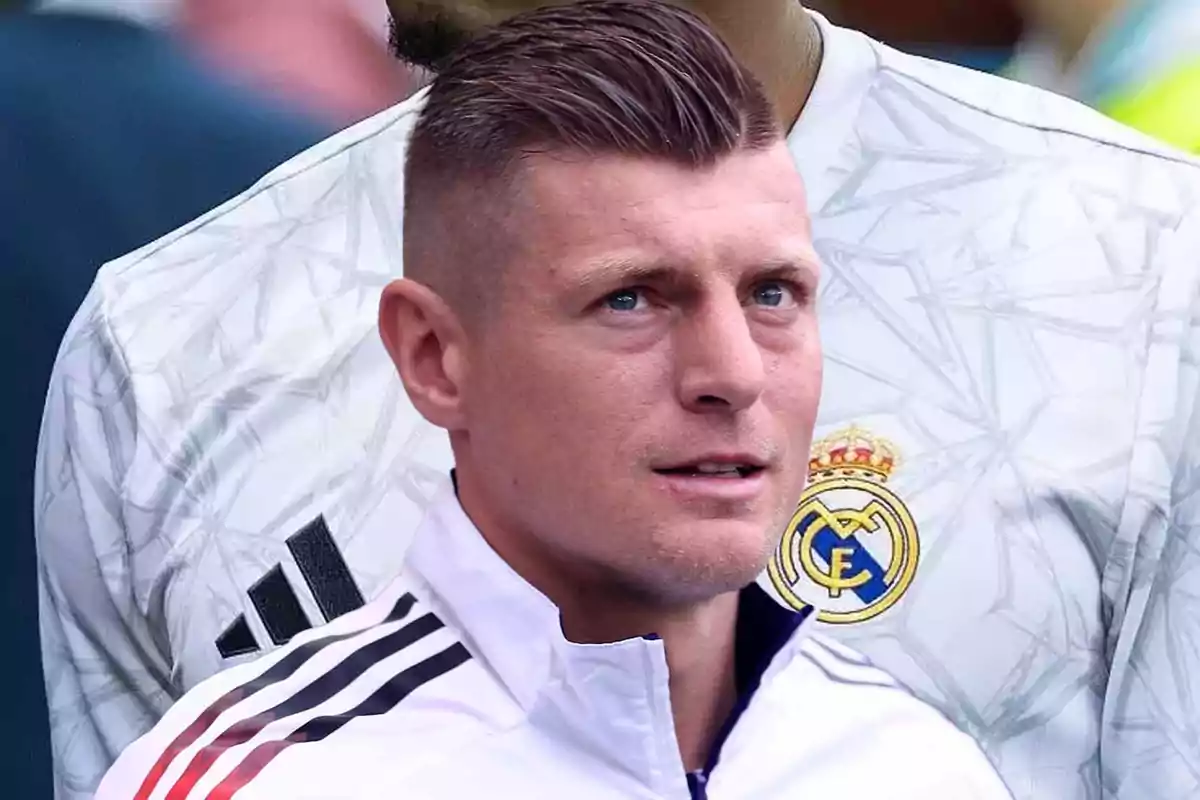 Un jugador de fútbol con uniforme blanco y el escudo de un equipo.