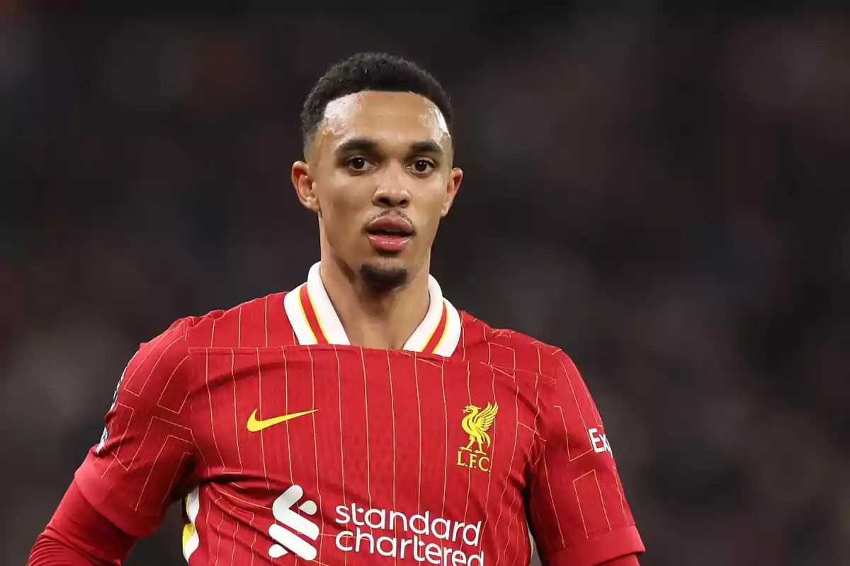 Jugador de fútbol con uniforme rojo del Liverpool en el campo de juego. Jugador de fútbol con uniforme rojo del Liverpool en el campo de juego.
