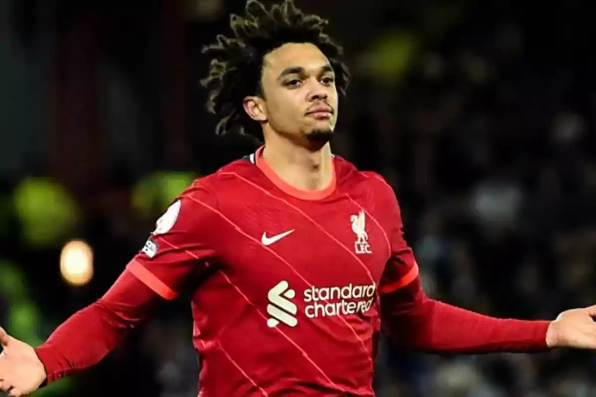 Football player in red Liverpool FC uniform on the field. Football player in red Liverpool FC uniform on the field.