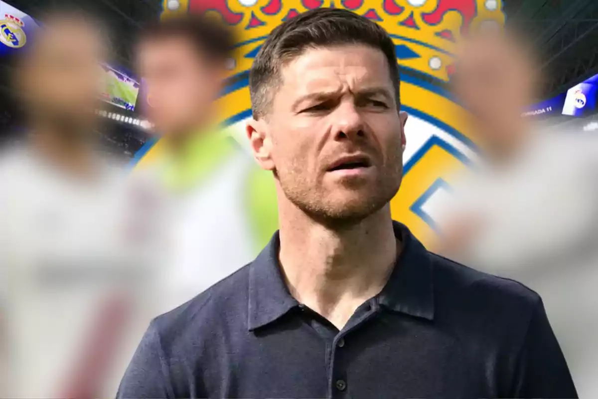 A man with a serious expression is in the foreground, with a blurred background that includes a soccer shield and out-of-focus figures.