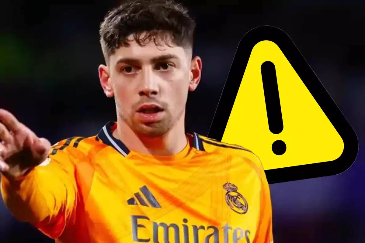 A player in an orange Real Madrid uniform gestures with his hand in front of a yellow warning symbol.