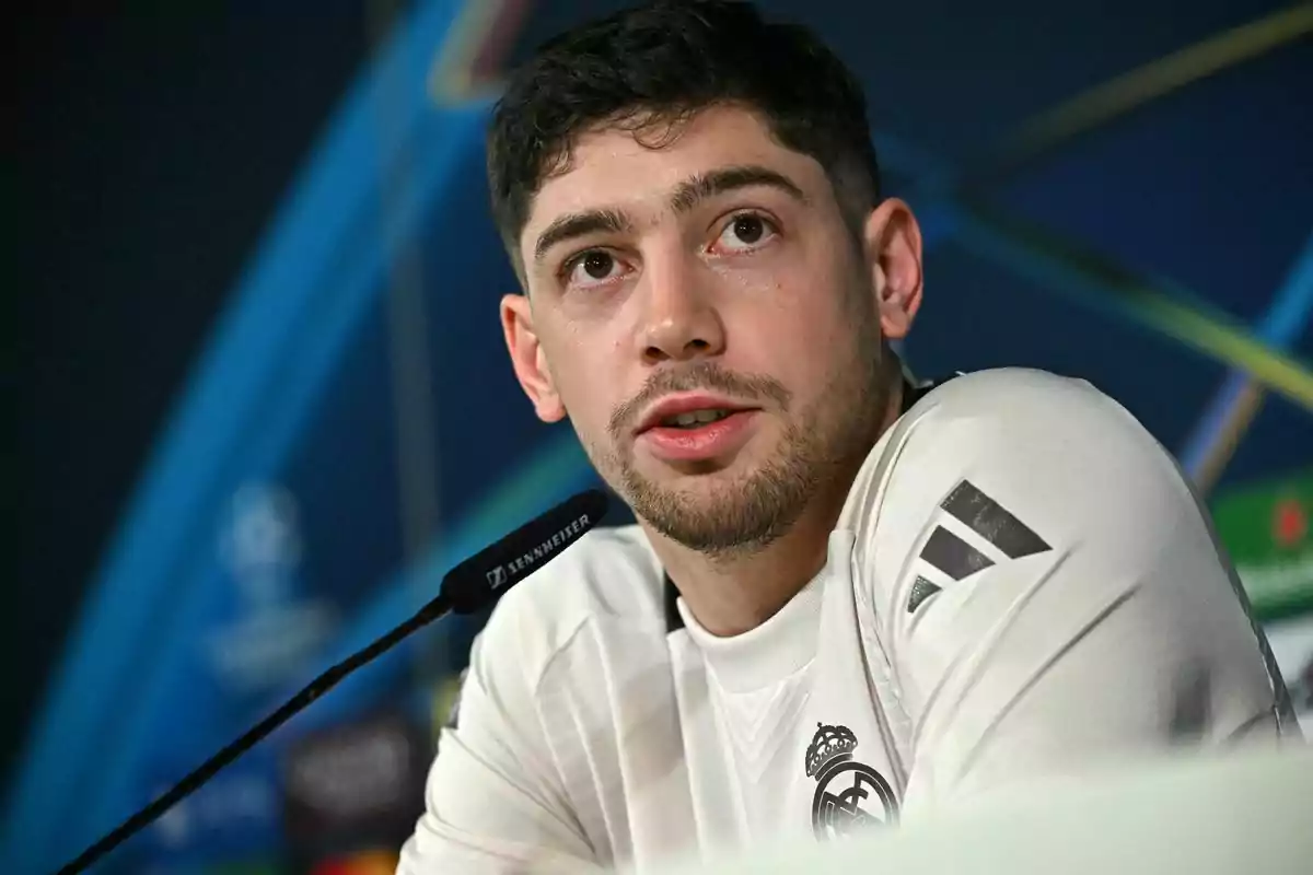 Un jugador de fútbol en una conferencia de prensa con un micrófono frente a él.