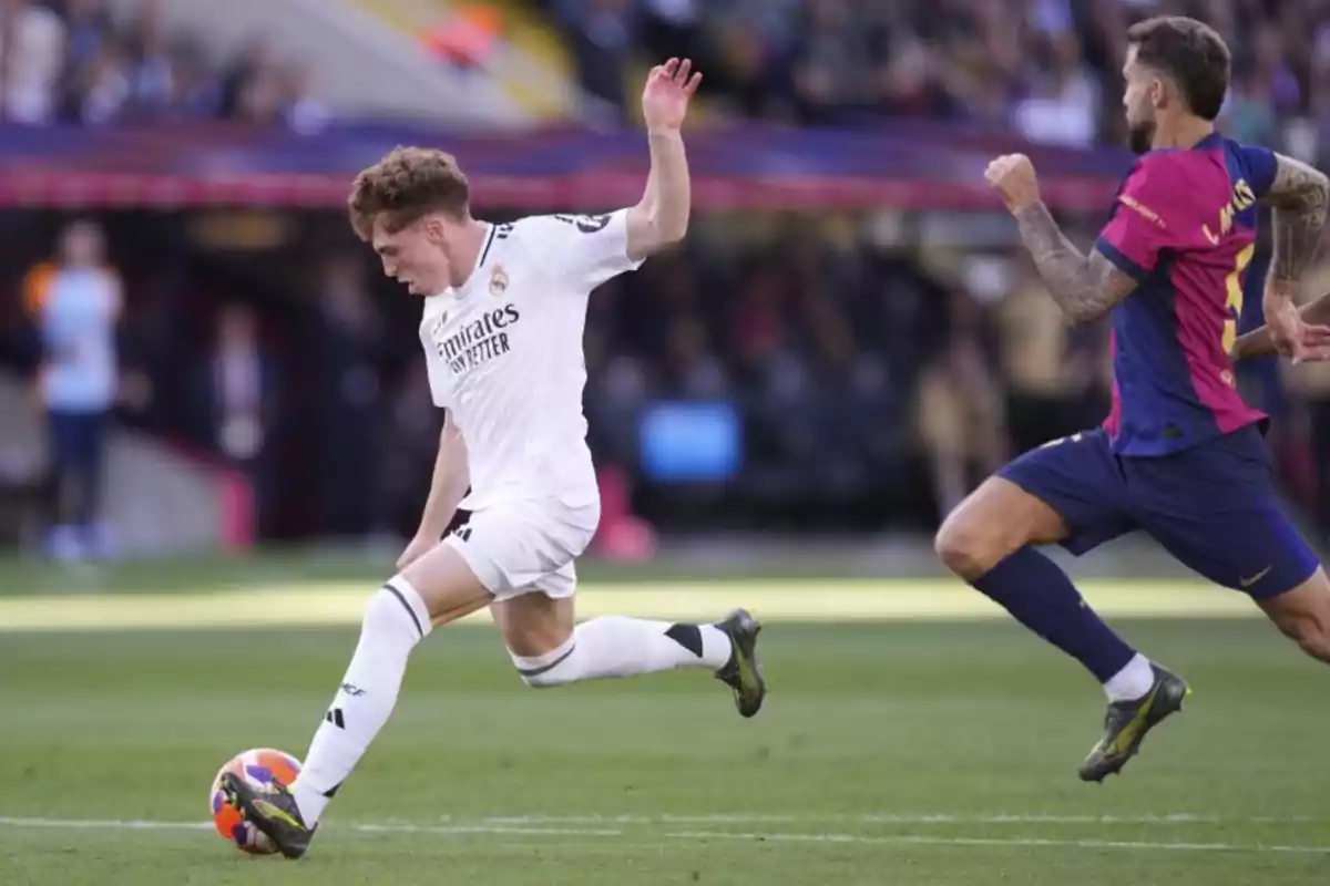 Two players in action during a match, one in a white uniform and the other in a blue and pink uniform in a stadium.