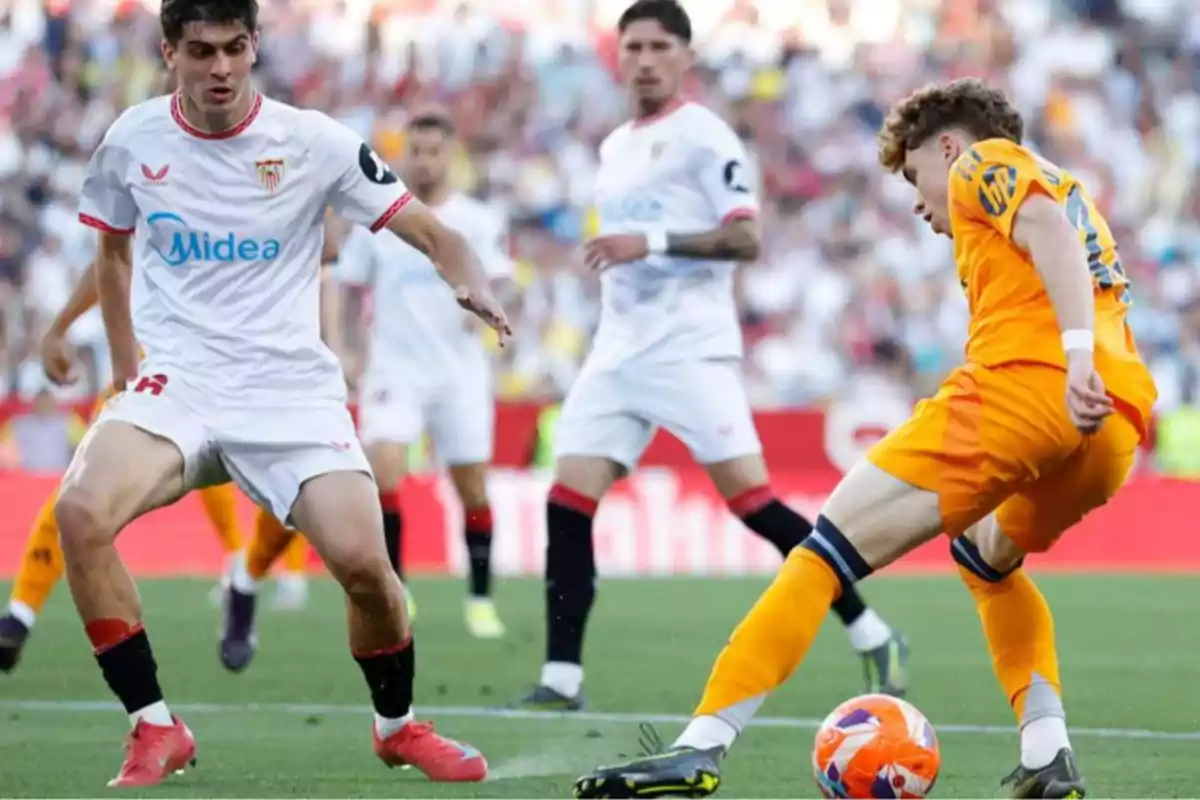 Soccer players contest the ball during a match in a stadium full of spectators. Soccer players contest the ball during a match in a stadium full of spectators.