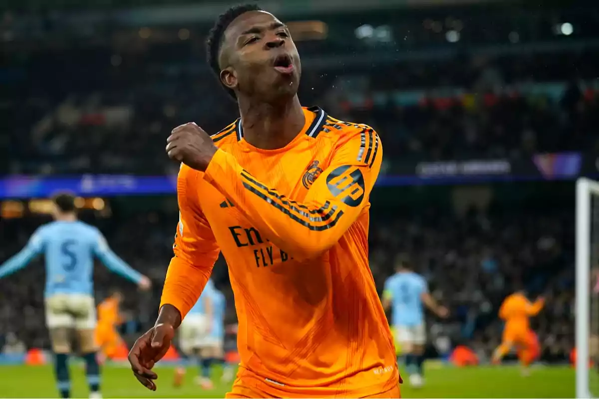 Un jugador de fútbol con uniforme naranja celebra en el campo durante un partido. Un jugador de fútbol con uniforme naranja celebra en el campo durante un partido.