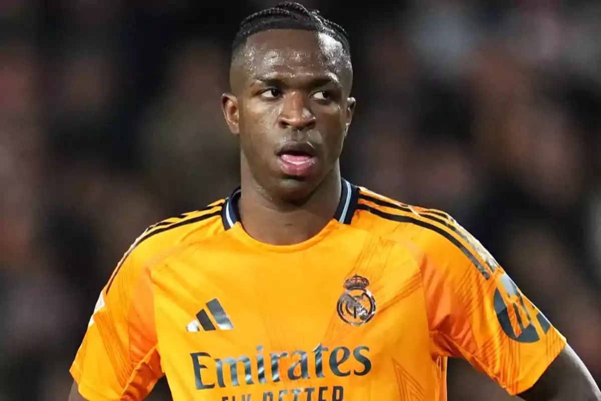 Football player in orange Real Madrid jersey on the field. Football player in orange Real Madrid jersey on the field.