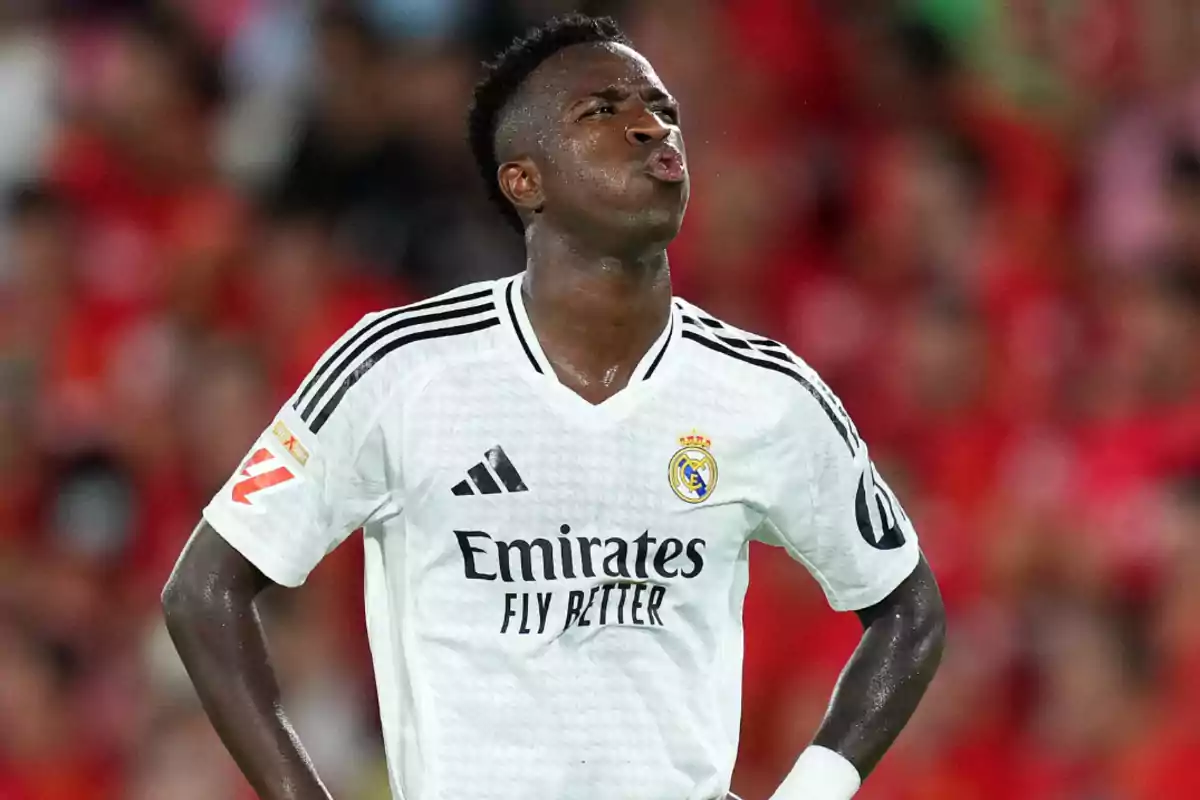 Jugador de fútbol con camiseta blanca del Real Madrid en el campo.