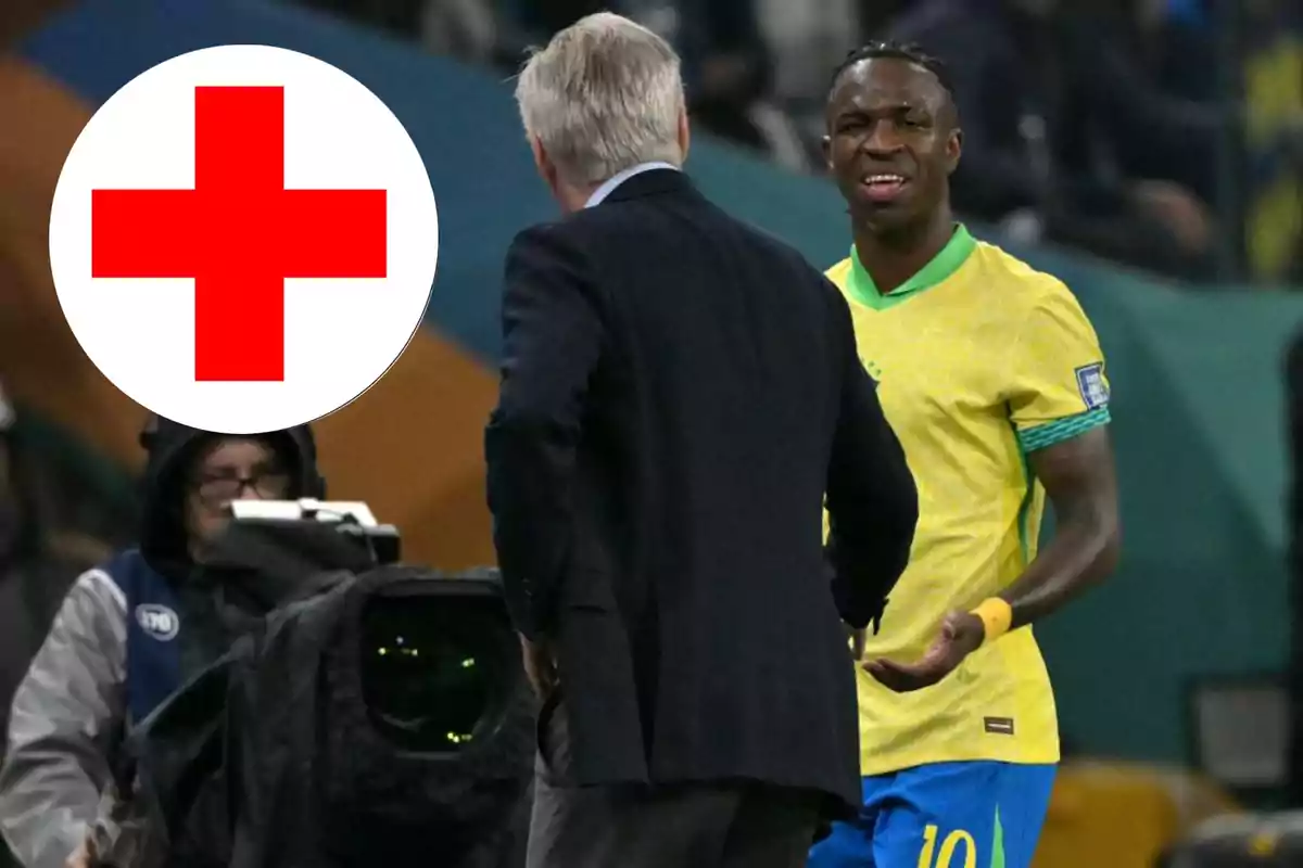 Un futbolista con gesto de dolor conversa con un hombre de traje mientras una gran cruz roja aparece en la imagen, sugiriendo una posible lesión durante un partido.
