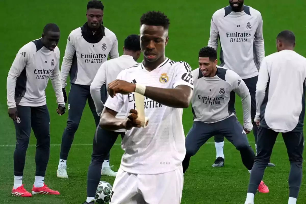 Jugadores de fútbol del Real Madrid entrenando en el campo, uno de ellos vendándose la mano.