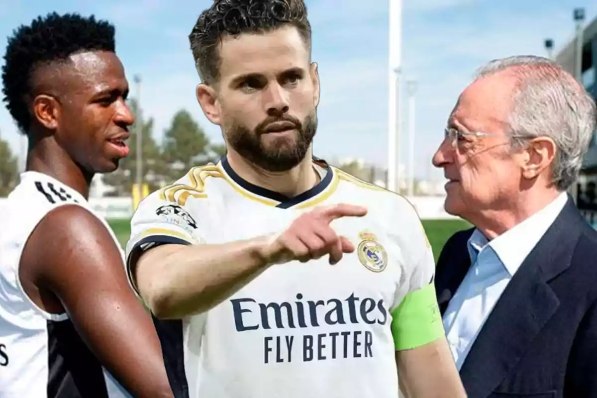 Tres personas conversando en un campo de entrenamiento de fútbol.