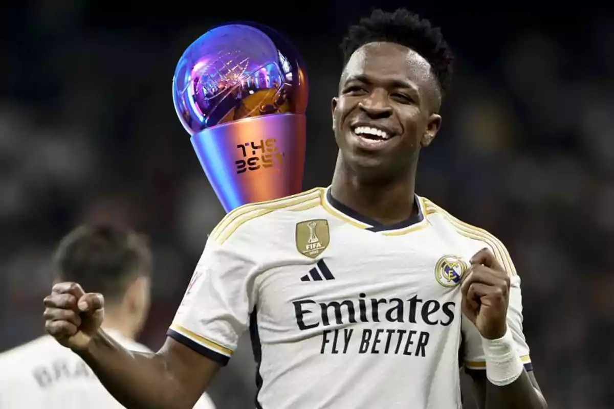 Soccer player smiling with a trophy in the background.