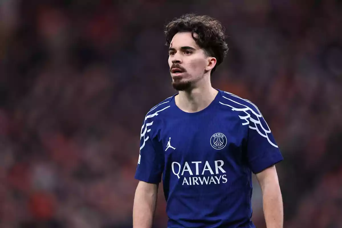 Un jugador de fútbol con uniforme azul del Paris Saint-Germain en el campo. Un jugador de fútbol con uniforme azul del Paris Saint-Germain en el campo.
