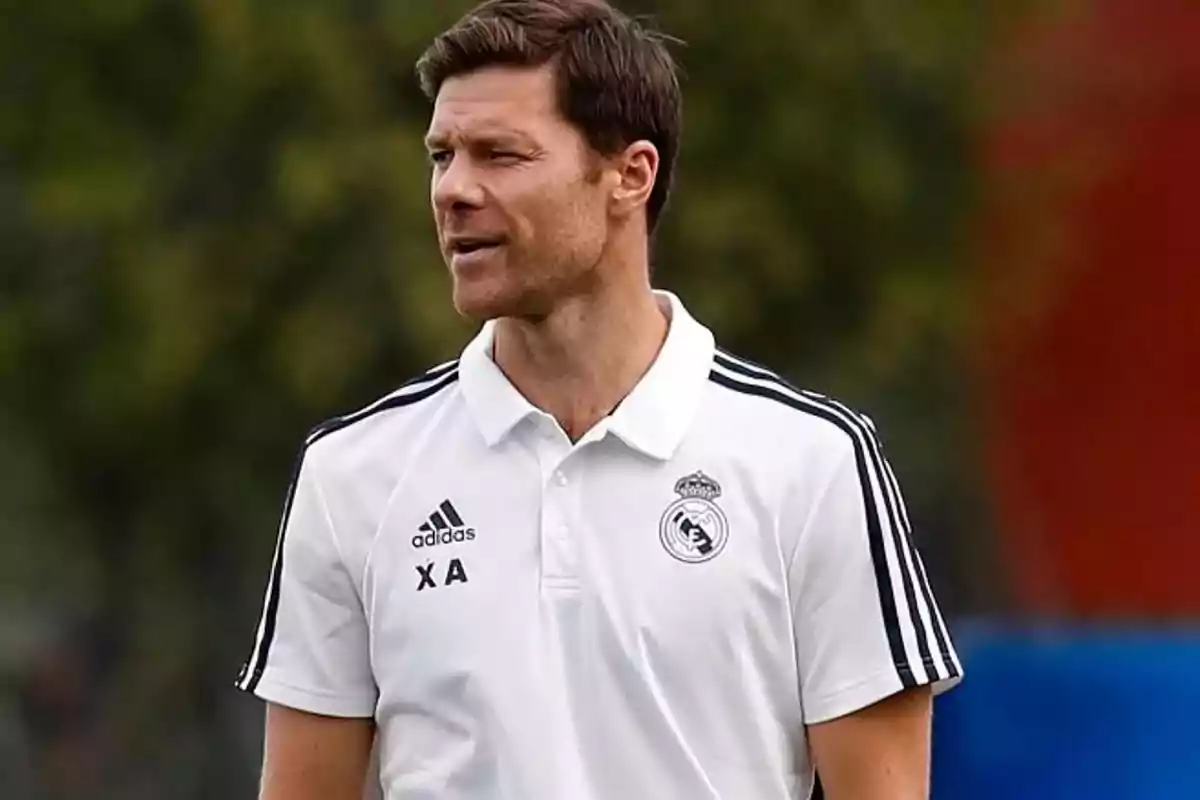 Man wearing a white Real Madrid training jersey on an outdoor field Man wearing a white Real Madrid training jersey on an outdoor field