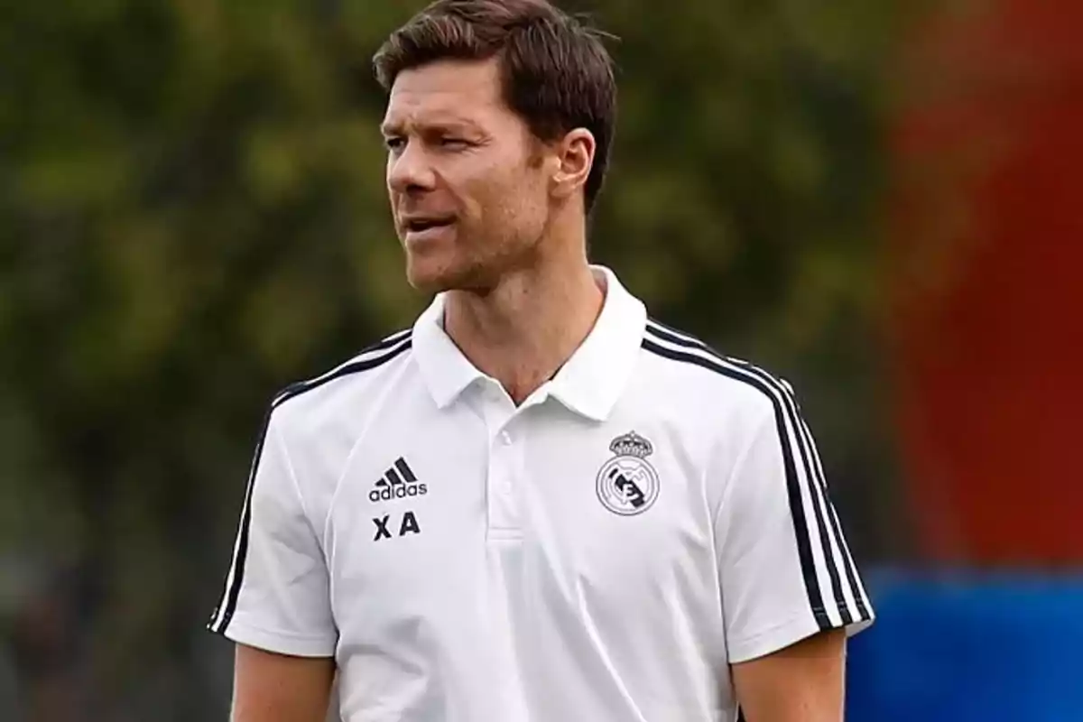 Hombre con camiseta blanca de entrenamiento del Real Madrid en un campo al aire libre Hombre con camiseta blanca de entrenamiento del Real Madrid en un campo al aire libre