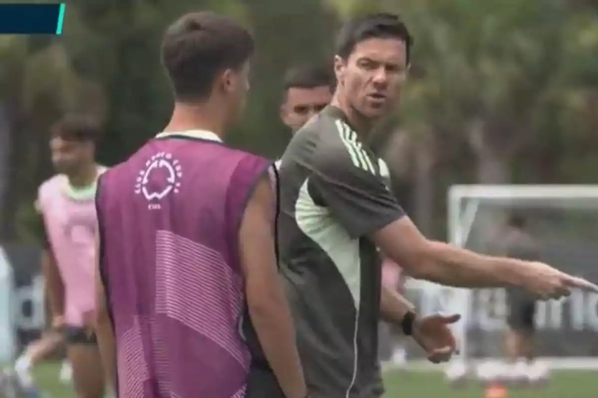 Soccer coach giving instructions to a player during a practice on the field Soccer coach giving instructions to a player during a practice on the field