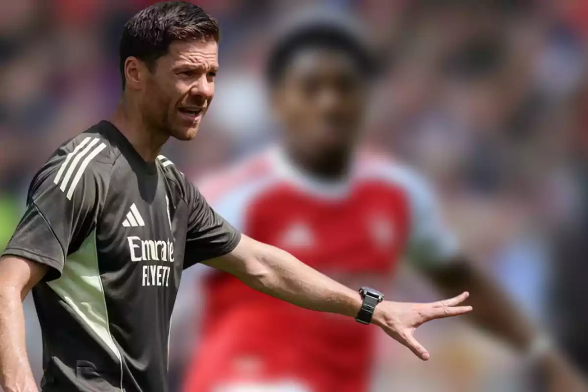 Soccer coach giving instructions on the field with a blurred player in the background